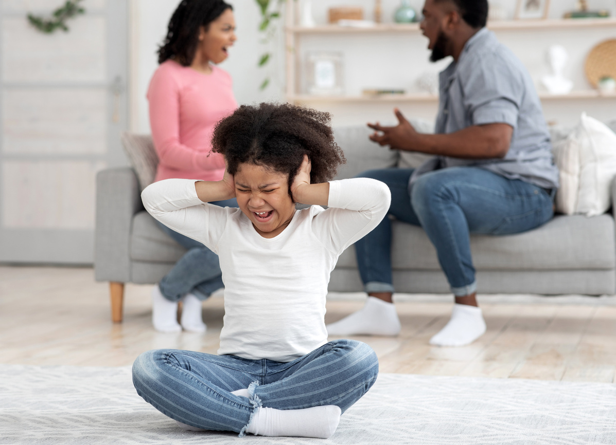 Childhood Traumas. Little Black Girl Covering Ears Not To Hear Parents Quarrels